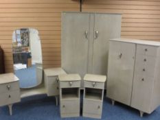 A LIMED OAK BEDROOM SUITE comprising wardrobe, compact dressing table and a pair of bedside