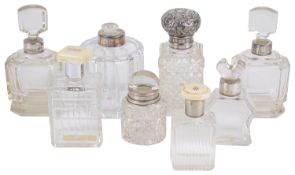 A collection of Edwardian and later glass and silver perfume/cologne bottles