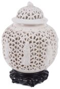 A 19th century Chinese blanc de chine reticulated lobed ginger jar and cove on hardwood stand