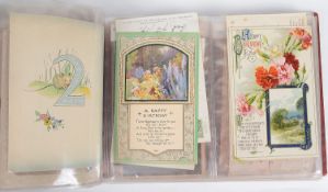 An album of mostly Edwardian and later postcards and greetings cards (Qty)
