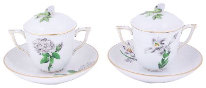 A pair of Herend porcelain twin handled botanical covered chocolate cups and stands