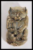 A brass vesta case modelled in the form of a cat playing with a mouse within its claws having a