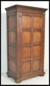 A 19th century Jacobean revival oak armoire - double wardrobe. Raised on large squat bun feet having