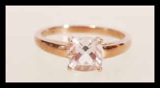 A hallmarked 9ct gold ring set with a cushion cut pink stone. Hallmarked Birmingham. Weight 2.1g.