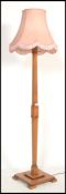 A vintage early 20th century Art Deco wooden standard lamp raised on square base with shaped