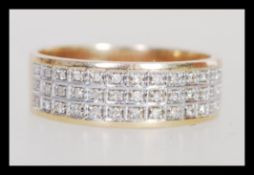 A hallmarked 9ct gold diamond band ring of wide form having three rows of in set diamonds. Weighs