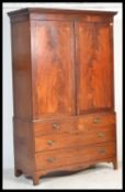 A 19th century George III mahogany linen press wardrobe being raised on bracket feet with 2 short