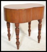 A Victorian 19th century kidney shaped mahogany bidet being raised on turned legs complete with