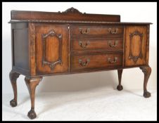 A 1930's Chippendale style mahogany sideboard credenza having a central bank of graduating drawers
