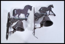 Two 20th century hand painted exterior cast iron metal wall hanging bells. Each with a hand