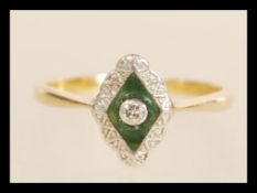 A stamped 18ct gold ring having a rhombus shaped enamelled panel set with a central round white