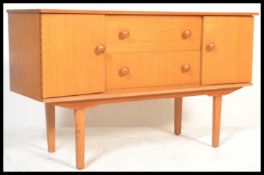 A vintage retro teak wood side board raised on four cylindrical legs with two central cupboard doors
