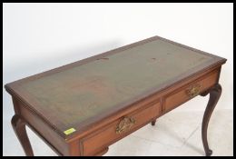An early 20th Century mahogany Edwardian writing desk, flared top with inset green skiver over two