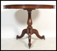 A good George III early 19th century mahogany tilt top breakfast table being raised on well