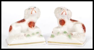 A pair of 19th Century Victorian Staffordshire miniature fireside dogs figurines raised on plinth