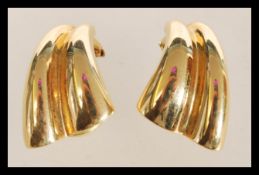 A 15ct gold pair of clip on earrings of double wave form. Weighs 5.6 grams.