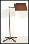 A Victorian mahogany and brass telescopic reading lectern stand being raised on a splayed cast