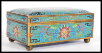 A 20th Century Cloisonne box / casket on a blue ground having red and pink floral decoration on a