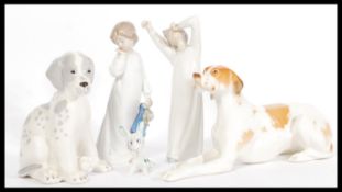 A pair of USSR Russian ceramic figurines of dogs along with a Nao figurine and a Lladro style