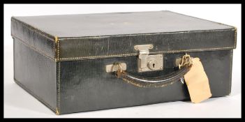A vintage 20th Century black leatherette suitcase having a metal lock and key and a leather handle