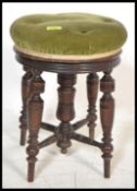 A late 19th / early 20th Century piano stool raised on four turned legs around a central turned