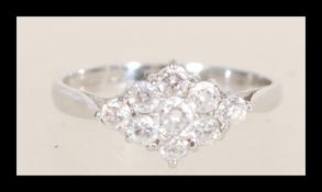 A hallmarked 9ct white gold cluster ring set with seven brilliant cut white stones. Hallmarked