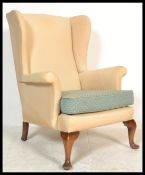 A vintage 20th century retro Parker Knoll wing back armchair raised on wooden pad feet. Measures: