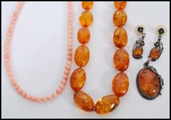 A selection of amber type jewellery to include a beaded necklace, a marked 925 silver pendant set