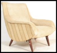 A vintage retro Danish style armchair having curved shaped arm rests on cylindrical beech angled