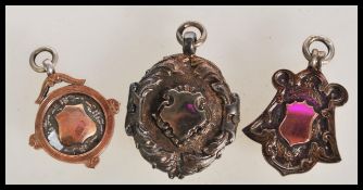 A group of three early 20th Century hallmarked silver pocket watch armorial fob medals - two of