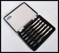 A vintage 20th Century set of six hallmarked silver knives having Queens pattern handles. Complete