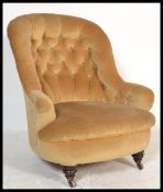 A 19th century Victorian mahogany open sided armchair being raised on mahogany turned castor legs