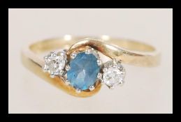 A hallmarked 9ct gold topaz and diamond ring having a crossover setting. Diamonds total approx