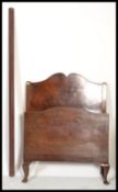 A 1930's mahogany Queen Anne revival mahogany single bed with shaped head and footboard united by