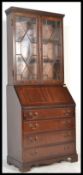 A 20th century mahogany bureau library bookcase being raised on shaped base with a bank of drawers