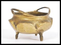 A 19th Century Chinese gilt bronze censer ding bowl raised on tripod feet with hoop handles. Six