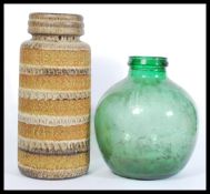 A West German ceramic stick stand with embossed patterning to the sides along with a green glass