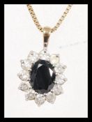 A pendant necklace having a hallmarked 9ct gold chain with a sapphire flower head pendant having a