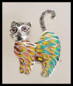 A sterling silver plique a jour cat brooch having marcasite decoration with ruby eyes. Weighs 8.7