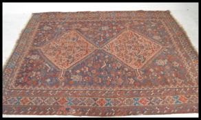 A 20th Century Turkish woven rug having a red ground with intricate geometric patterning including