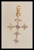 A stamped 375 9ct gold crucifix pendant set with six brilliant cut white stones. Weight 2.7g.