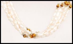 A vintage 20th century baroque pearl multi strand necklace having tigers eye and gold spacers and
