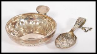 A vintage early 20th Century continental silver wine tasting bowl having hoop handle along with a