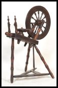 A 19th century North Country mahogany spinning wheel having treadle base with spindle set wheel
