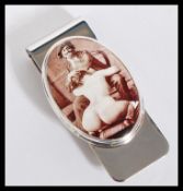 A sterling silver novelty money clip having an enamel panel depicting an erotic scene. Stamped 925