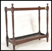 A Victorian 19th century mahogany stick stand in the manner of Shoolbred, London. Raised on turned