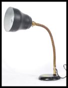 A vintage retro 20th Century industrial anglepoise desk lamp raised on a circular base with brass