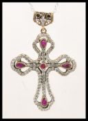A silver pendant necklace having a large Gothic style crucifix pendant set with cubic zirconia and