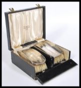 A pair of early 29th Century silver hallmarked brushes in a fitted J. Benson Ltd case. Hallmarked
