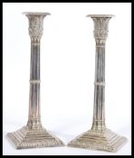 A pair of Mappin & Webb silver plated candlesticks having square stepped bases with moulded